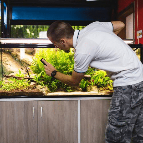 Technician cleaning and inspecting saltwater aquarium equipment